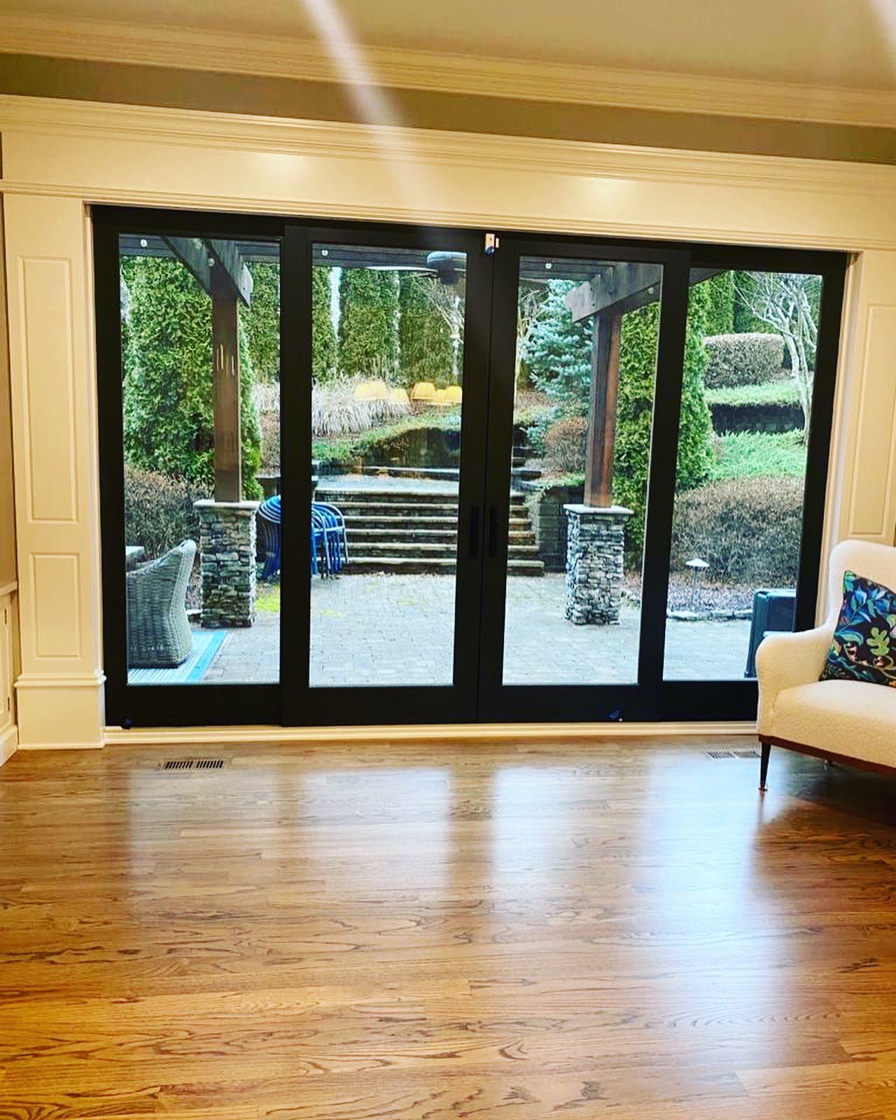 A living room with hardwood floors and sliding glass doors leading to a patio.