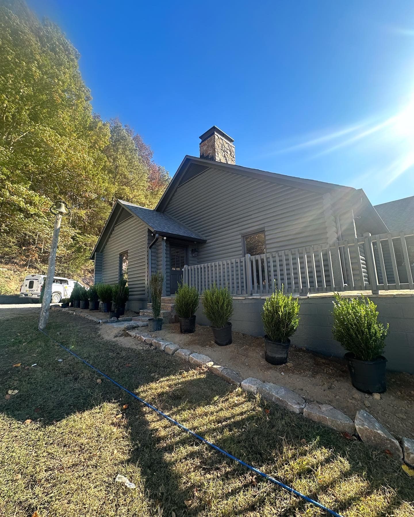 A house with a lot of potted plants in front of it.