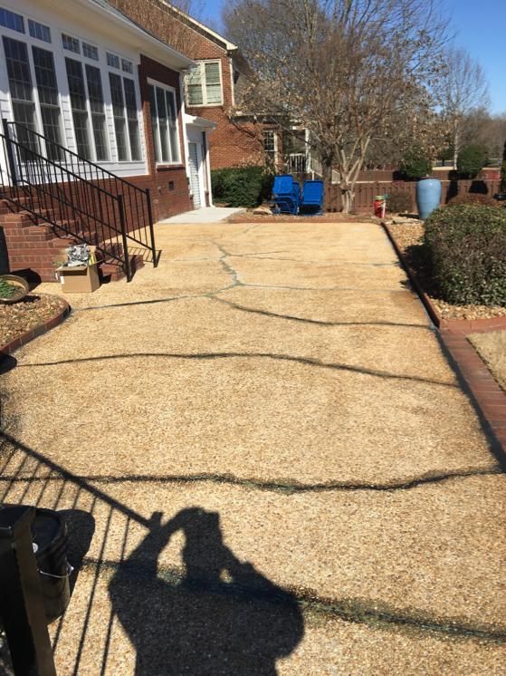 A shadow of a person is cast on the sidewalk in front of a house.
