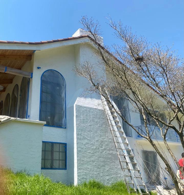 A white house with a ladder in front of it