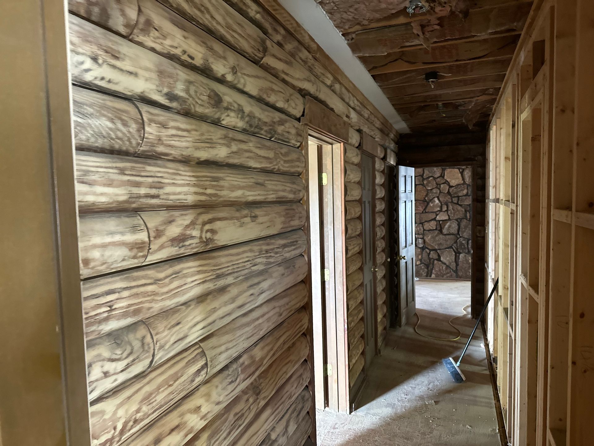 A hallway with wooden walls and doors in a house under construction.