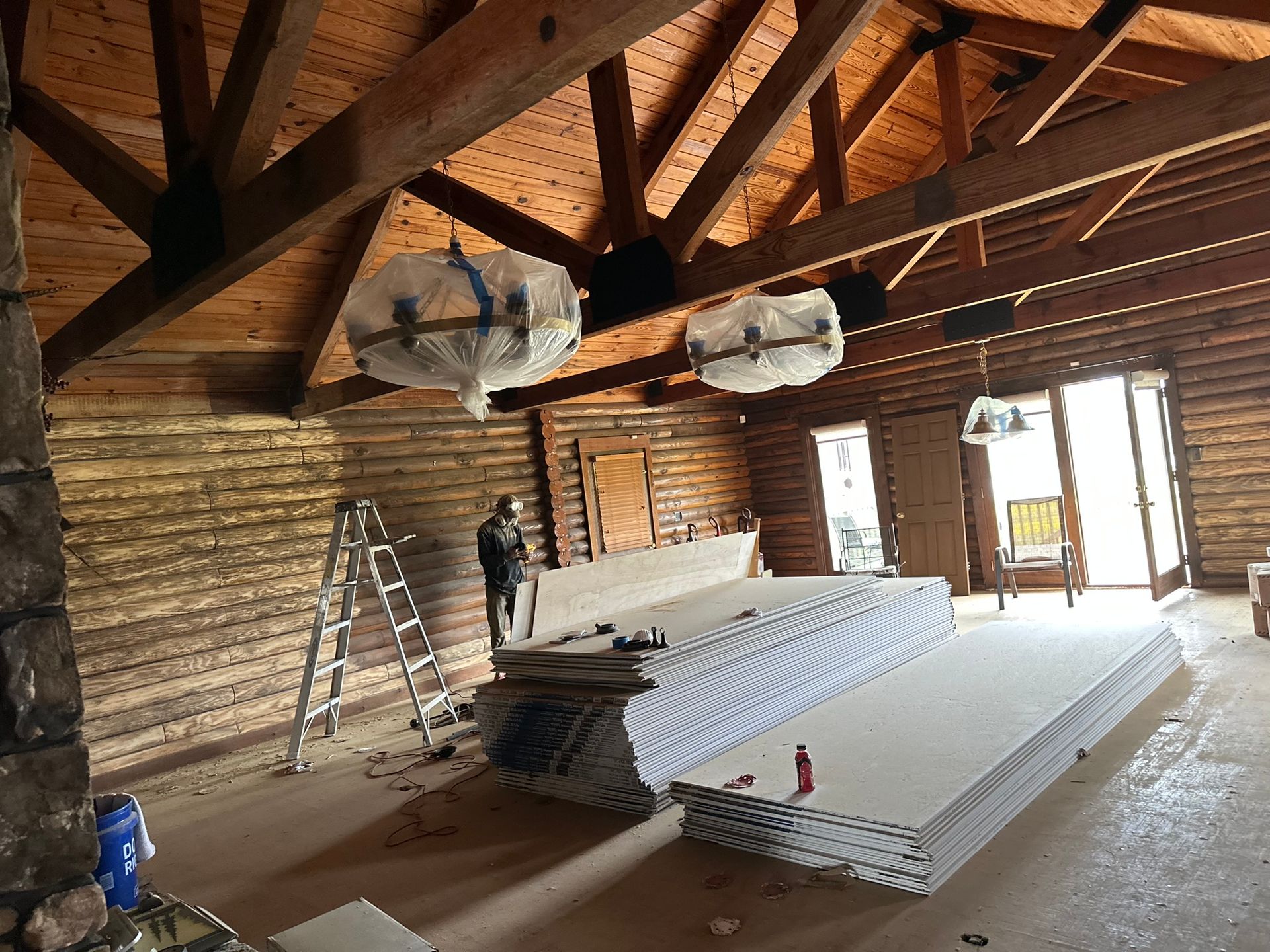 A large room with wooden beams and a ladder