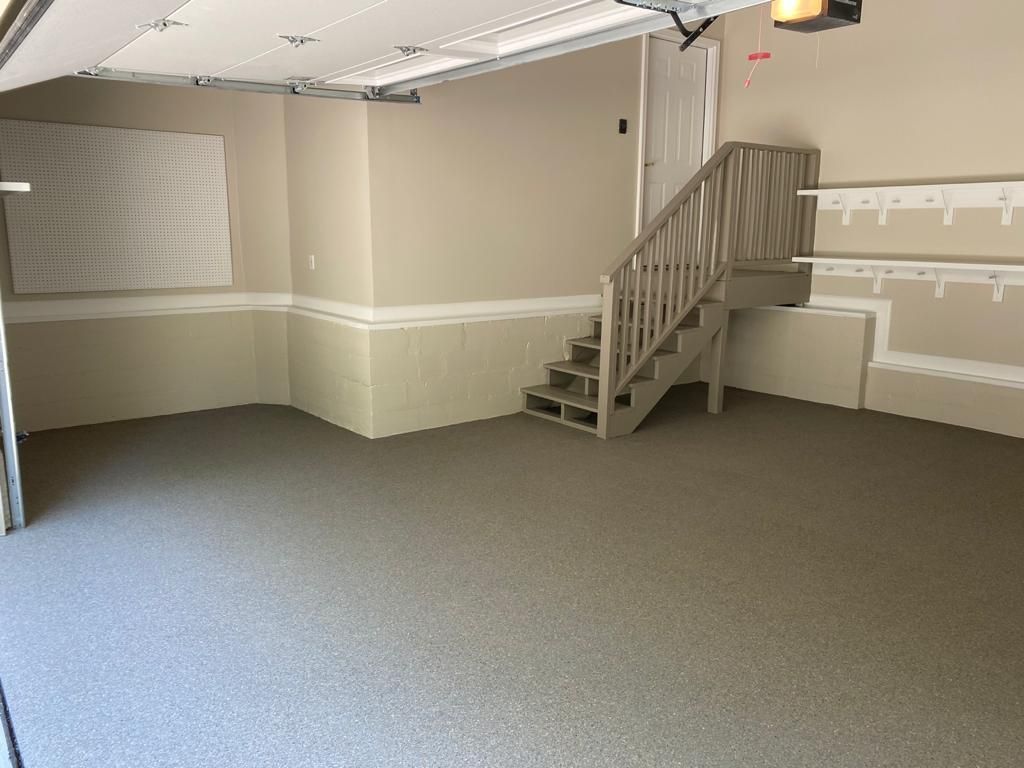 An empty garage with stairs leading up to the second floor.
