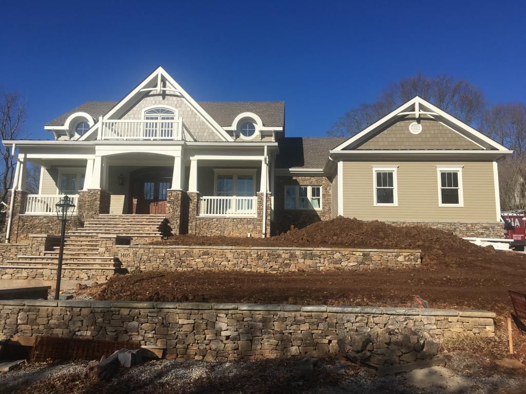 A large house with a stone wall in front of it