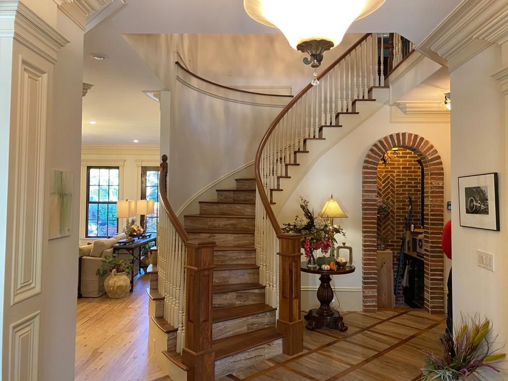 A spiral staircase in a hallway with a brick archway