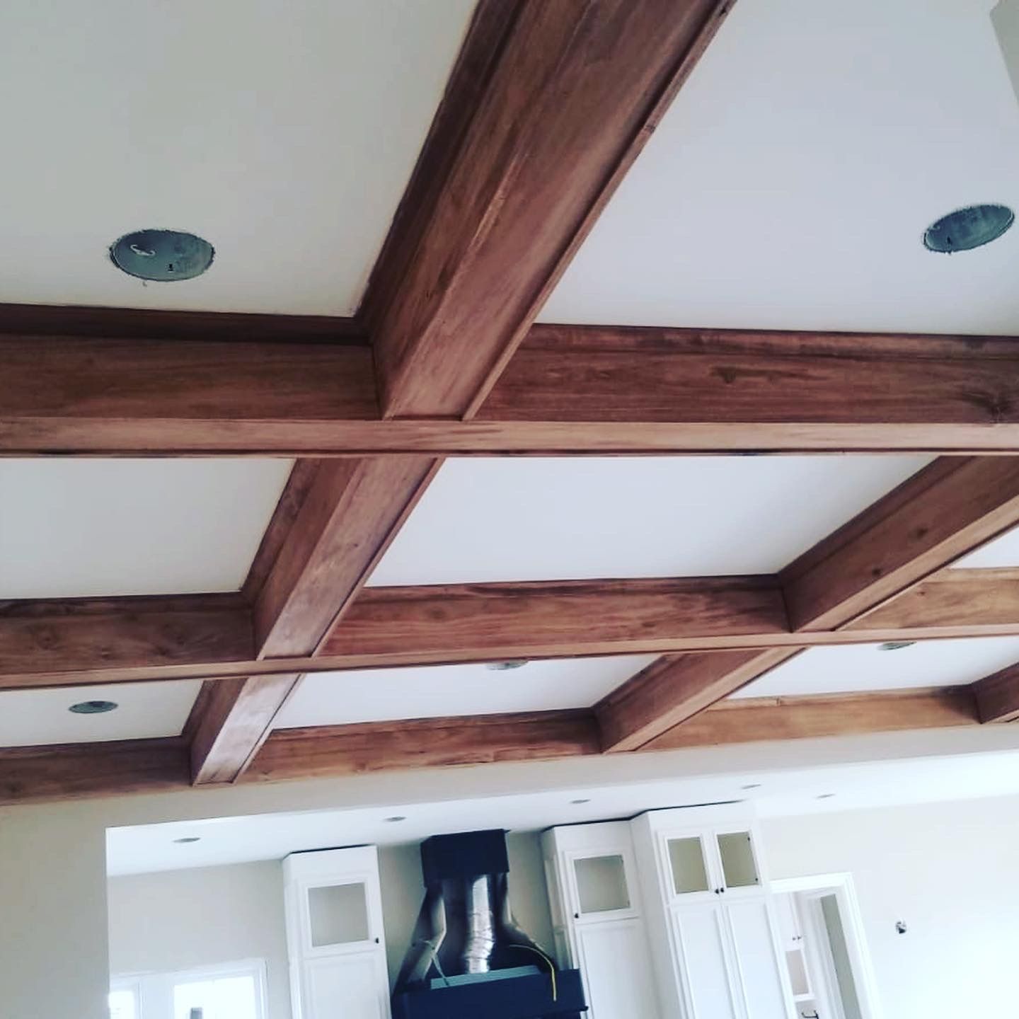 A ceiling with wooden beams and a white ceiling
