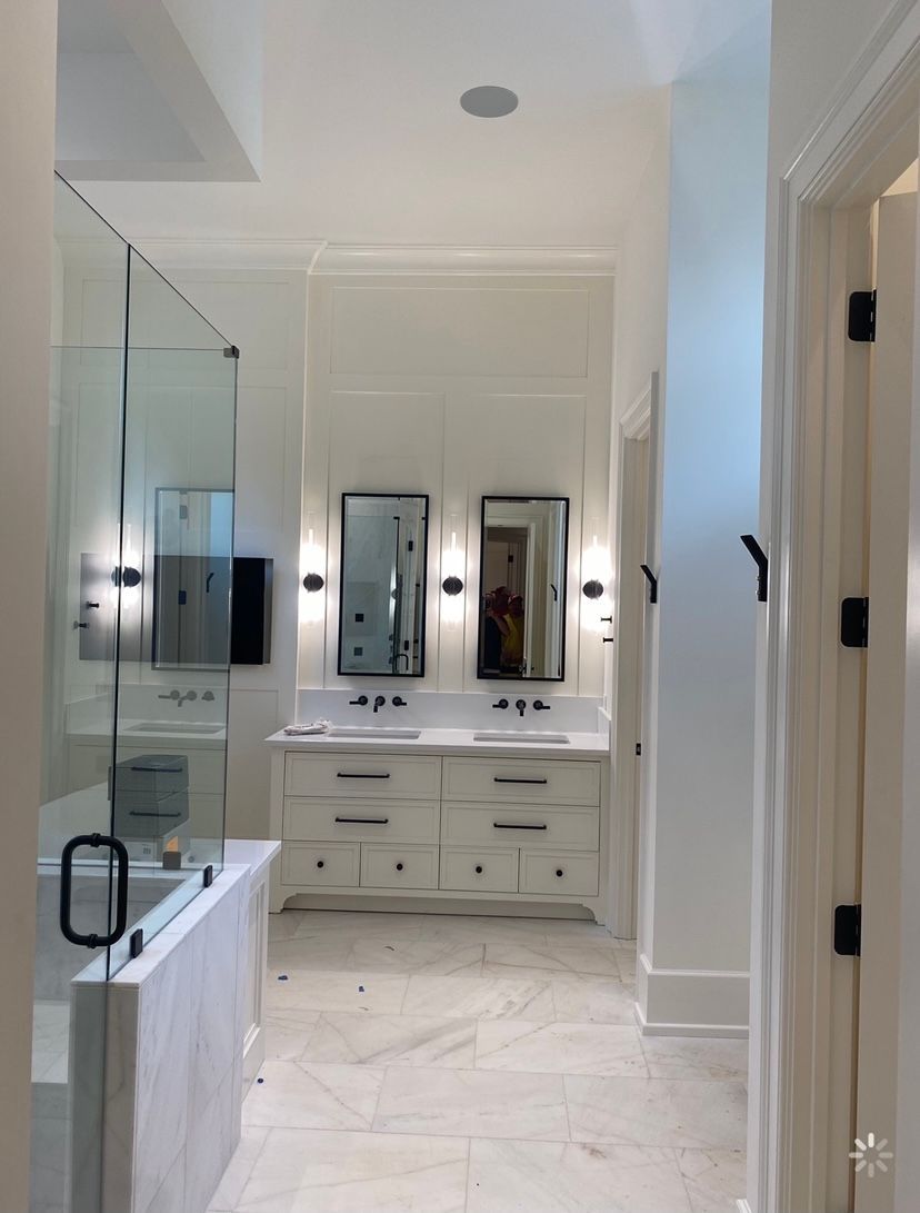 A bathroom with two sinks and a walk in shower