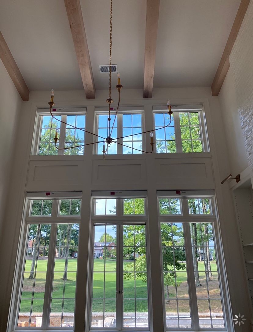 A room with a lot of windows and a chandelier hanging from the ceiling