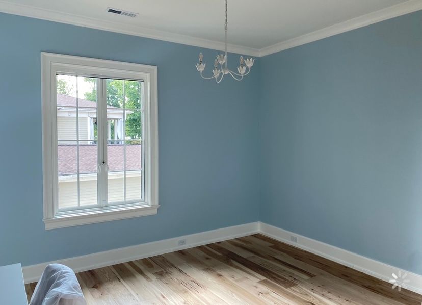 An empty room with blue walls and a window