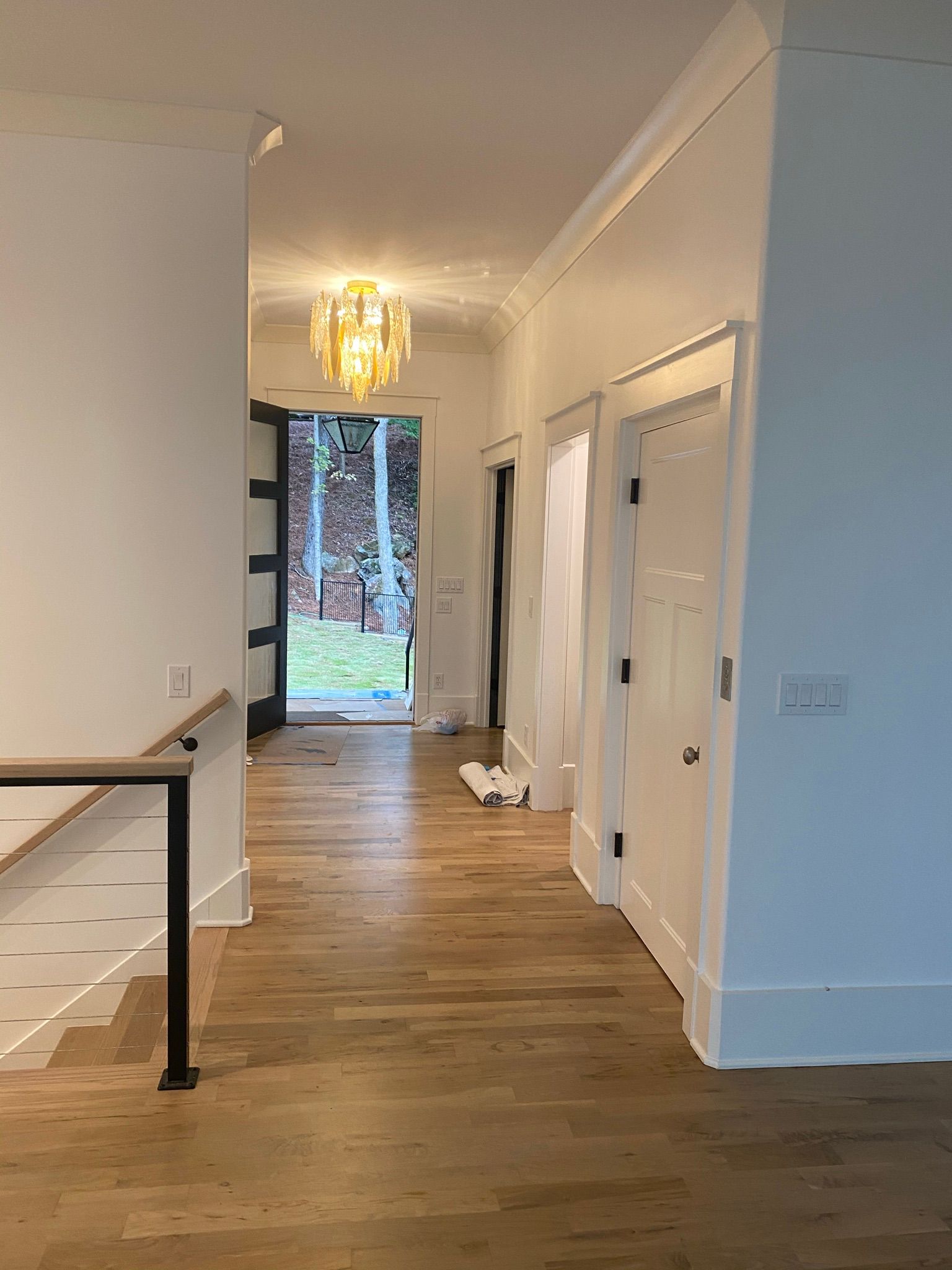 A hallway with wooden floors and white walls in a house.