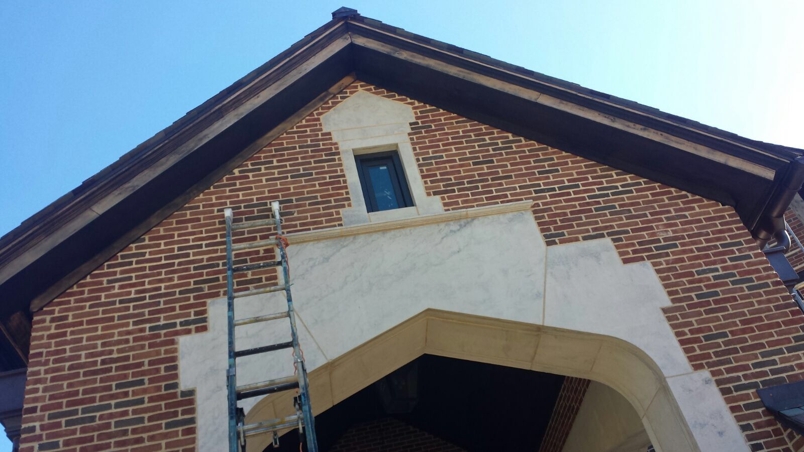 A ladder is hanging from the side of a brick building