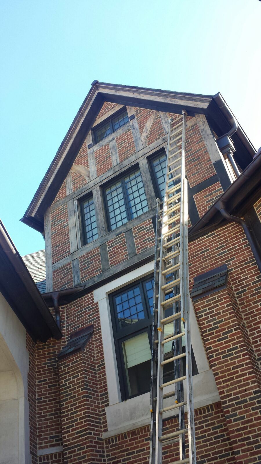 A ladder is attached to the side of a brick building.