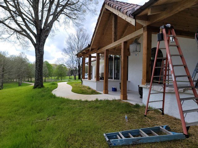 A ladder is sitting on the grass in front of a house.