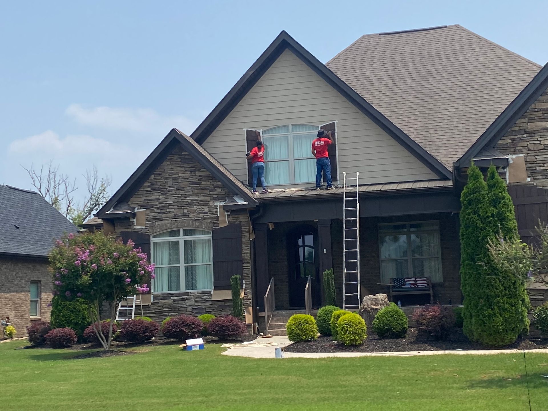 Two men are working on the roof of a house