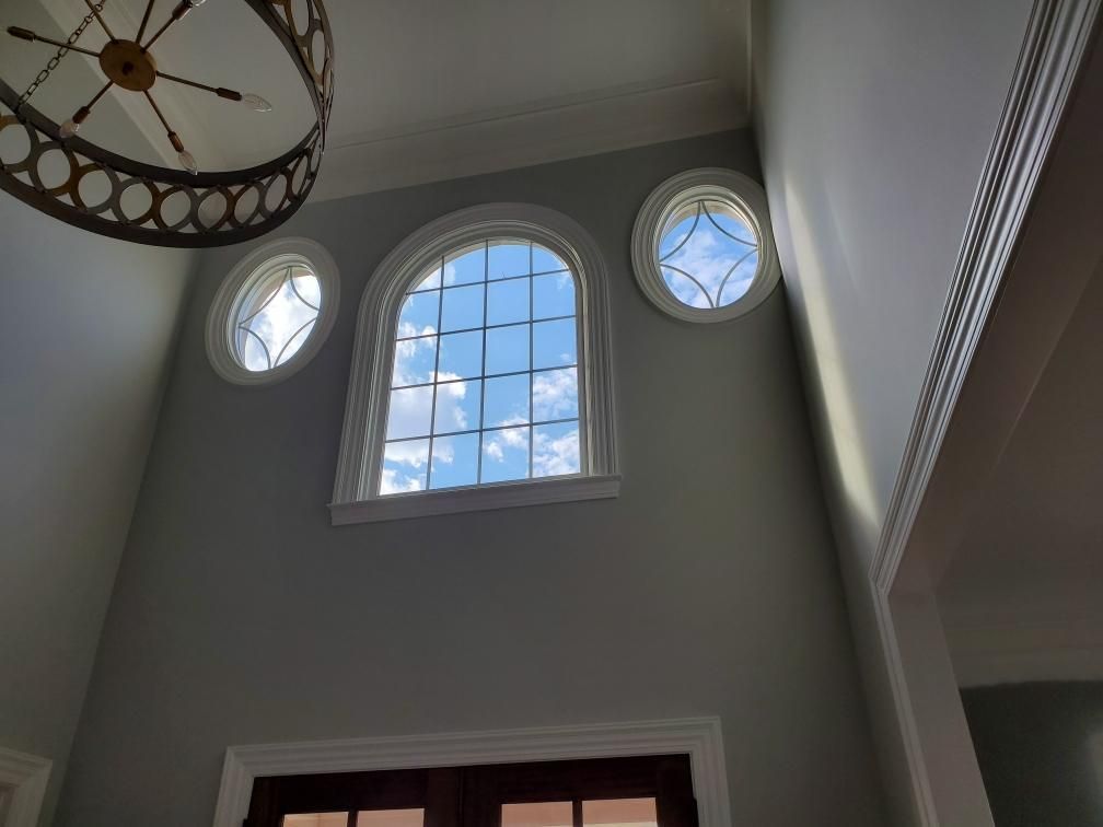 Looking up at a window with a chandelier hanging from the ceiling
