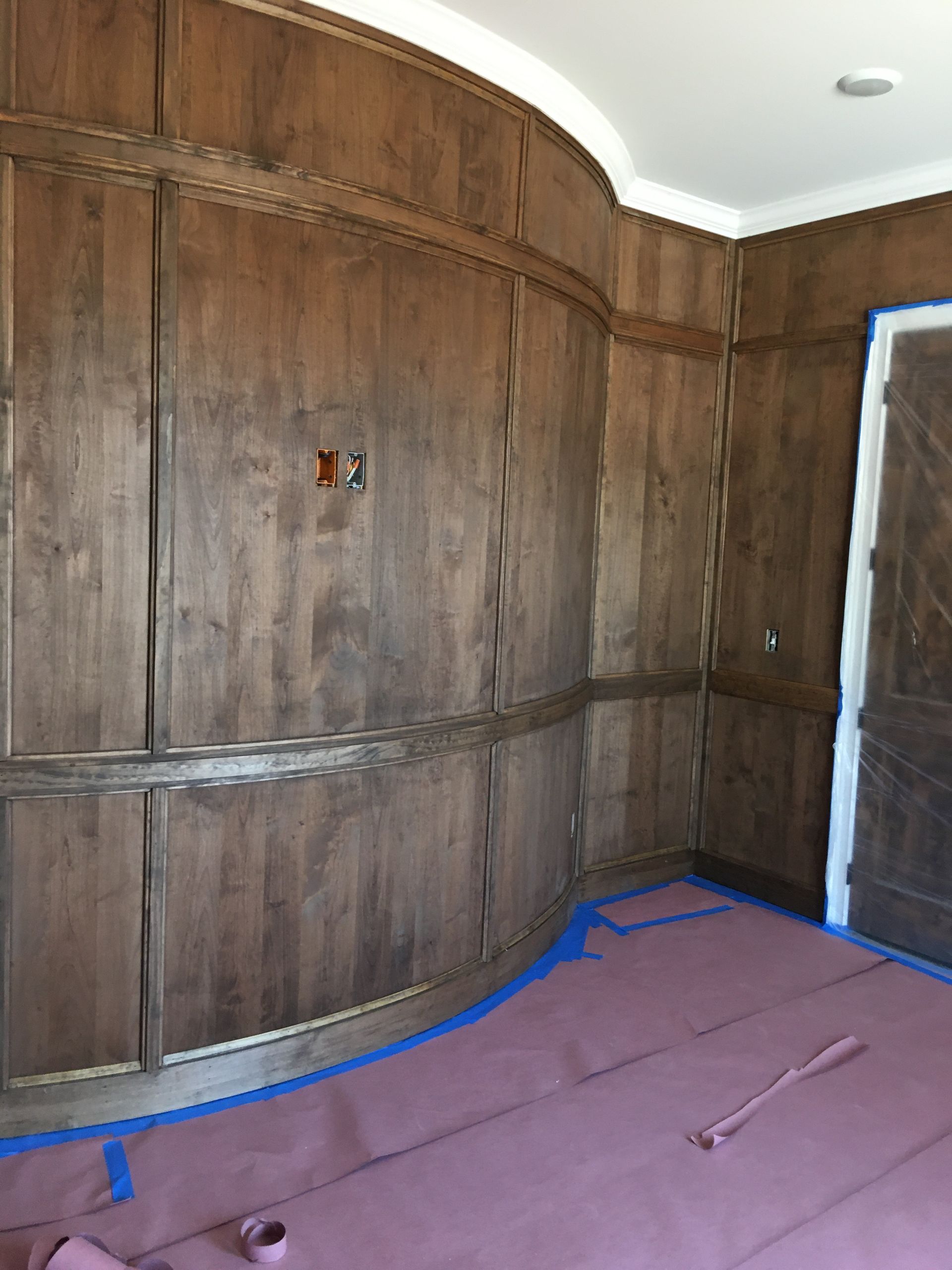 A room with wood paneling and a pink mat on the floor