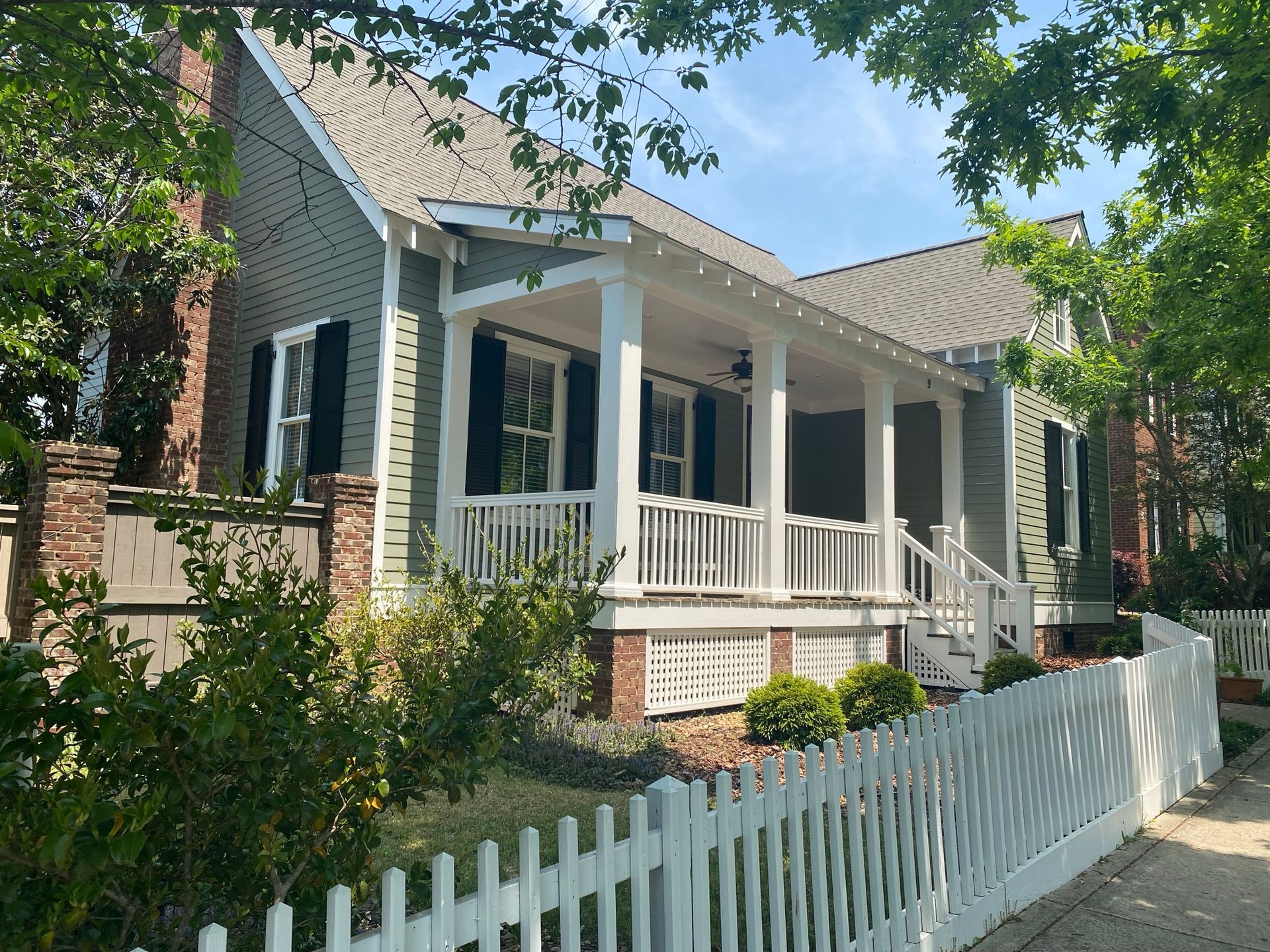 A house with a porch and a white picket fence