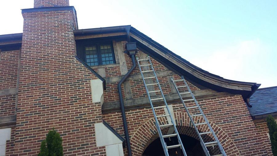 Ladder is Sitting on the Side of a Brick House