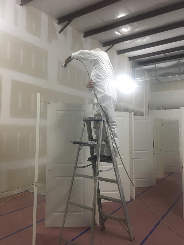 Worker with Ladder Painting a Wall