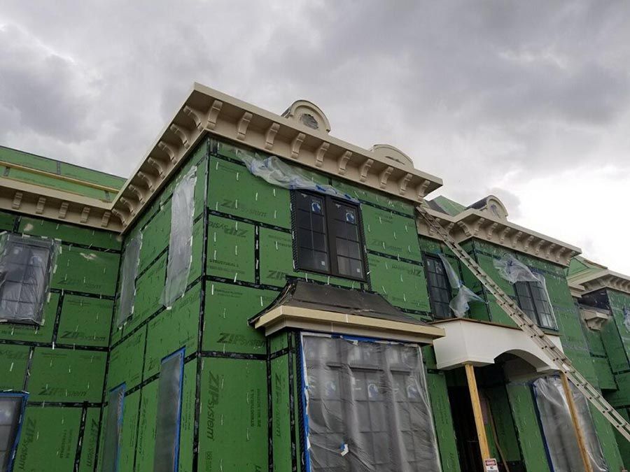 House is Being Built and is Covered in Green Insulation