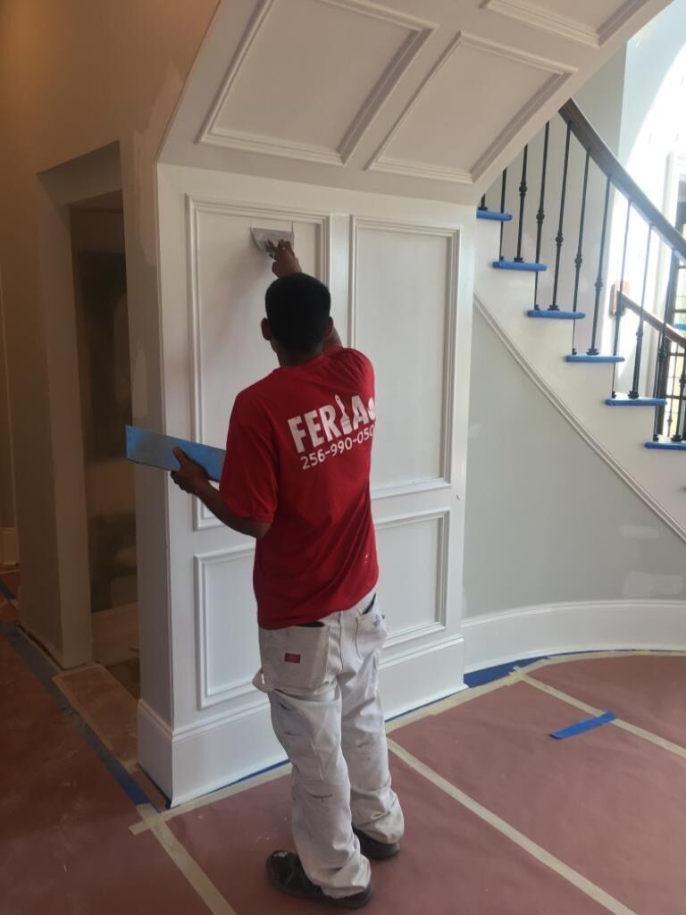 Worker Painting a Wall Next to a Staircase