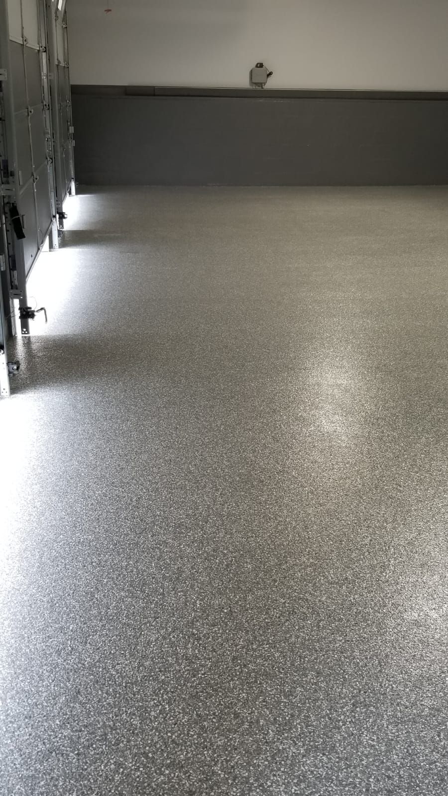 A garage with a gray floor and a gray wall.