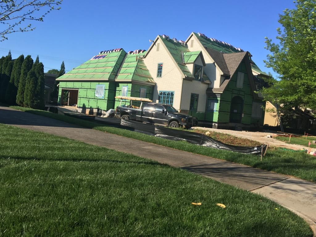 A large house with a green roof is being built.