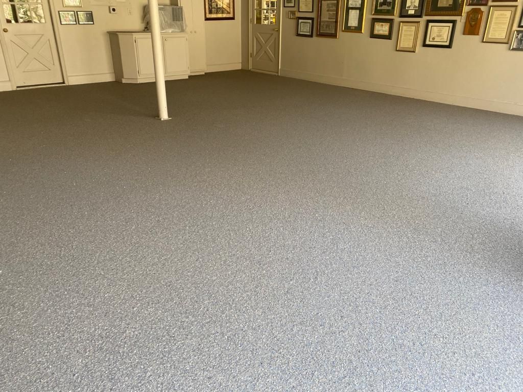 A room with a lot of pictures on the wall and a carpeted floor.