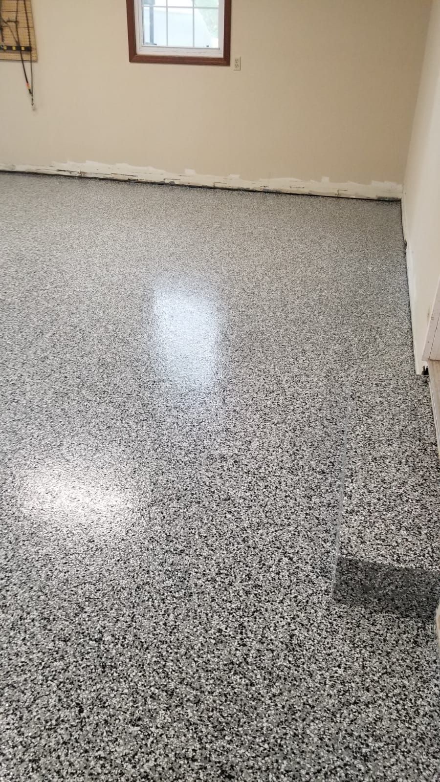 A room with a gray floor and a window.