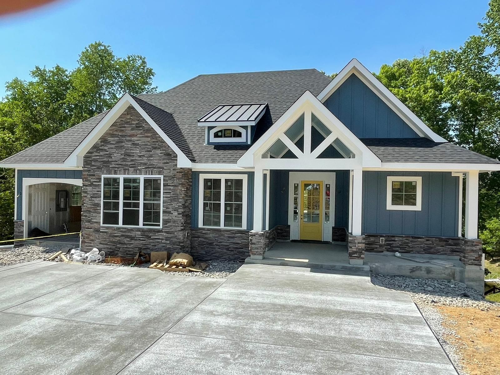 A blue house with a white trim and a yellow door