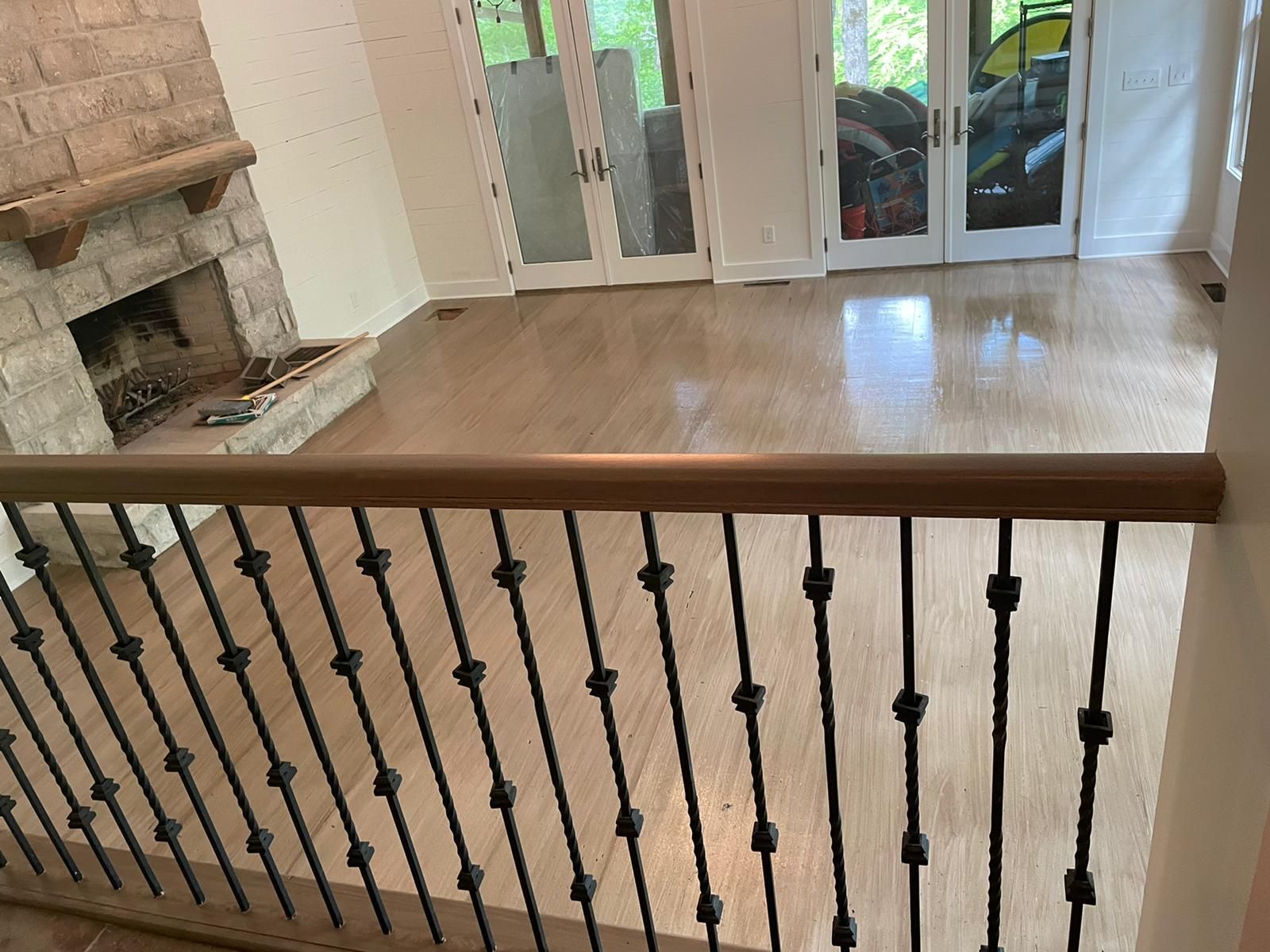 A living room with a fireplace and a wrought iron railing.