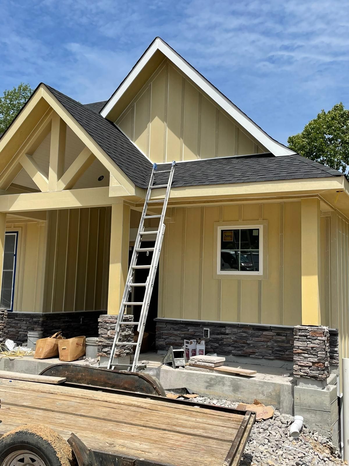 A house is being built with a ladder on the side of it.