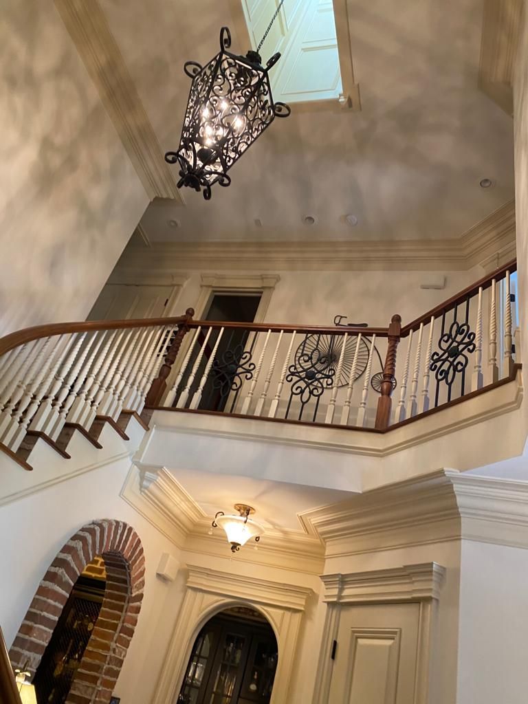 A staircase in a house with a chandelier hanging from the ceiling.