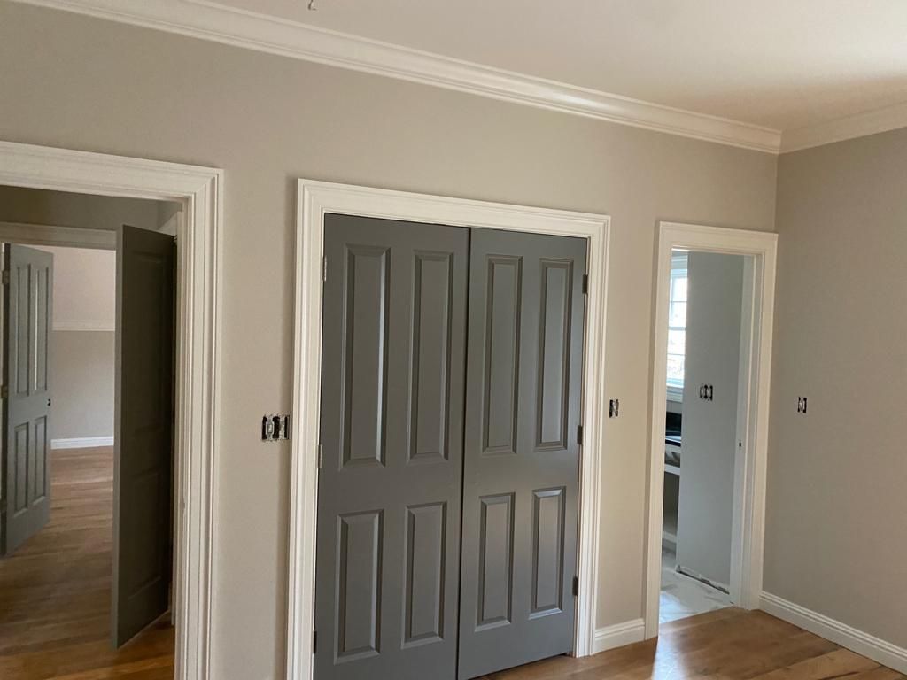 An empty room with gray doors and white trim.