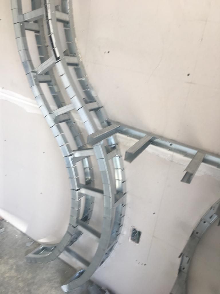 A metal ladder is sitting on the floor next to a wall.