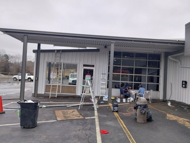 A fire hydrant is in front of a building that is being painted