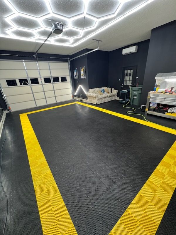 A garage with a black floor and yellow lines on it