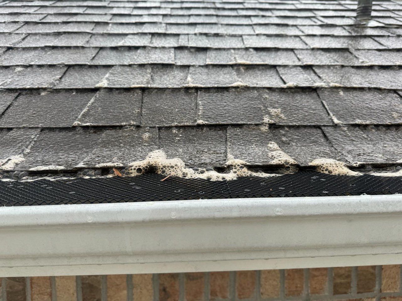 A close up of a roof with a gutter on it.