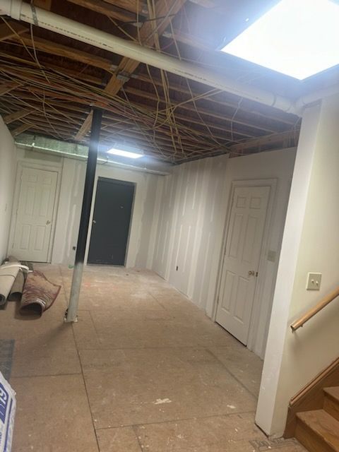 A basement with a wooden ceiling and stairs.