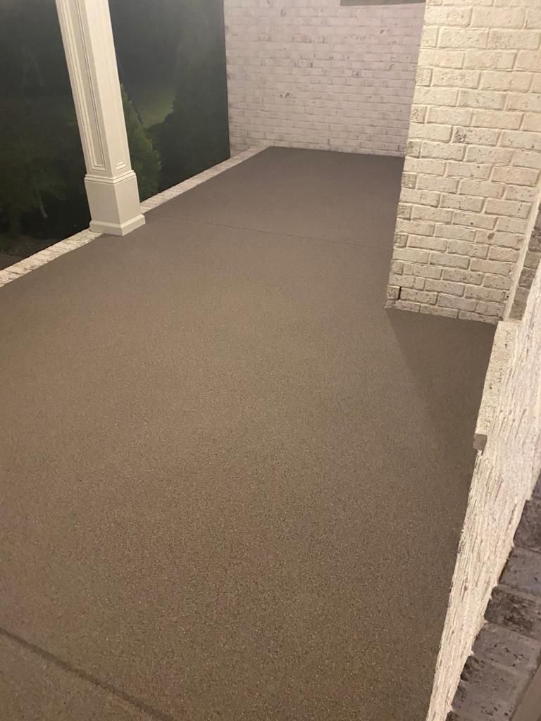 A porch with a carpeted floor and a white brick wall.