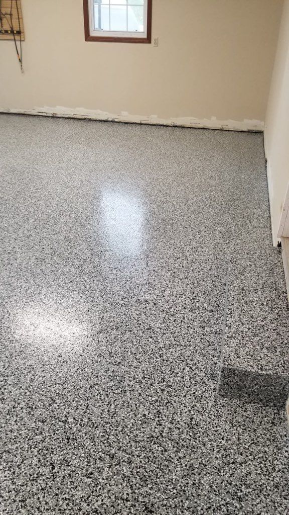 A room with a gray floor and a window.