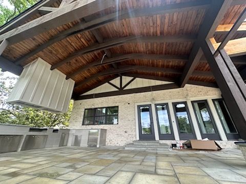 A large house with a covered patio and a wooden roof.