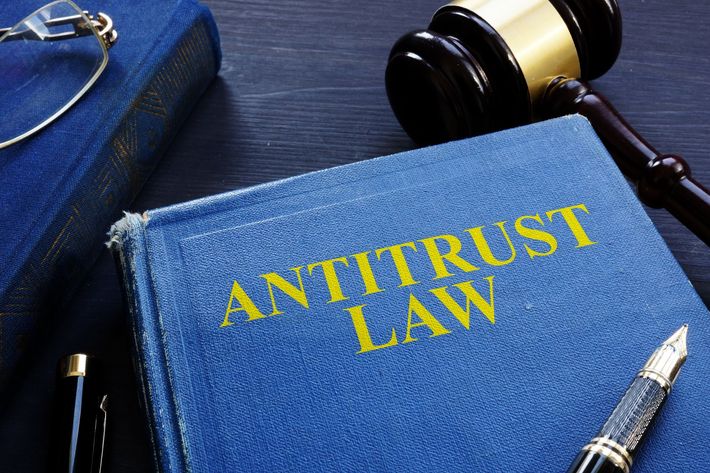 A blue book titled antitrust law next to a judge 's gavel