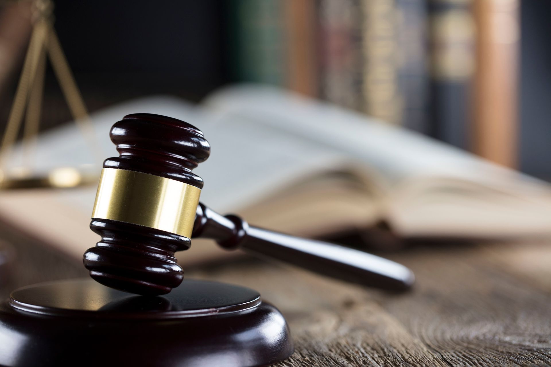 A wooden judge 's gavel is sitting on a wooden table.