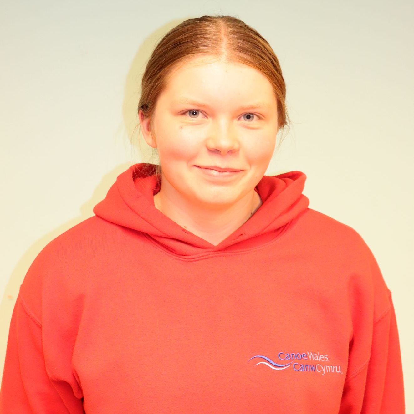A woman wearing a red hoodie that says cambridge on it