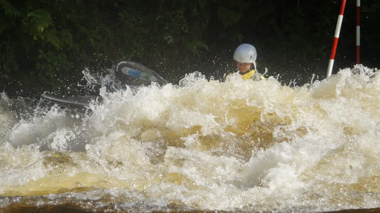 A person is riding a kayak down a river.