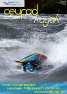 A person is riding a kayak down a river.