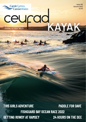 A man is riding a wave on a kayak on the cover of a magazine.