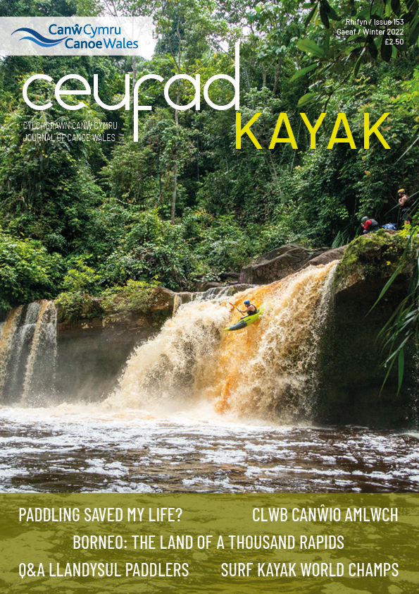 A magazine cover with a waterfall and a person in a kayak on it.