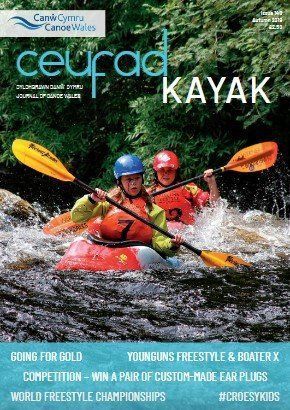 A couple of people are paddling kayaks down a river.